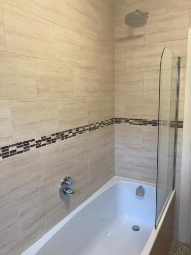 Das Bad ist mit einer Badewanne mit einer Dusche ausgestattet. in der Unterkunft Apartment 8 The Landings in Filey