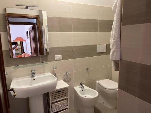 a bathroom with a sink and a toilet and a mirror at Appartamenti Aspromonte in Milan