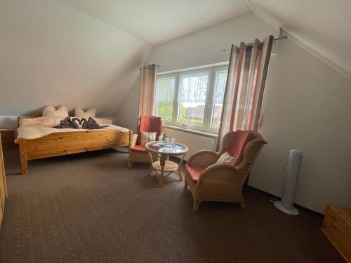 een slaapkamer met een bed en een tafel en stoelen bij Pension Restaurant Pizzeria Lion in Krummhörn