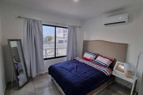 1 dormitorio con cama y ventana grande en Hermoso Departamento nuevo con acceso a Alberca en Mazatlán