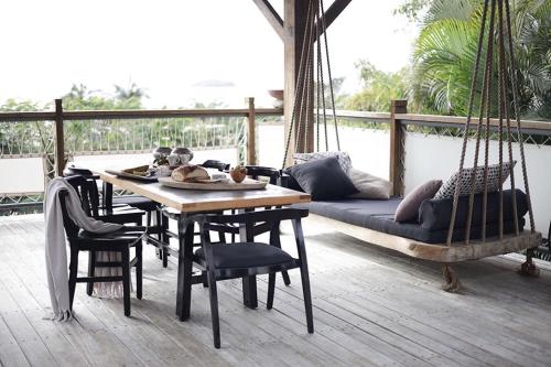 porche con columpio, mesa y sillas en THE BEACH HAVENS en Emerald Beach