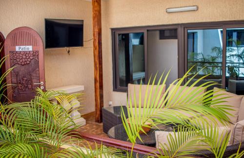a living room with a tv and some plants at Résidence Hôtelière Lauria in Lomé