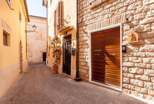 an alley with two garage doors and a brick building at Lo Speziale - Paccasassi in Sirolo