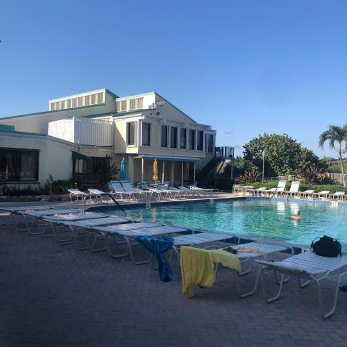 a swimming pool with lounge chairs and a resort at Beach bungalow at Ocean Village in Fort Pierce