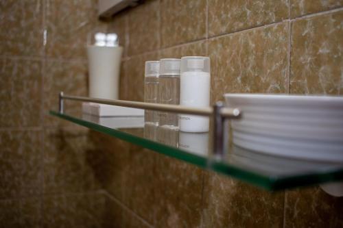 a glass shelf in a bathroom with cups and plates at Résidence Hôtelière Lauria in Lomé