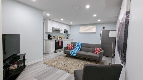 a living room with a couch and a kitchen at SERENE & MODERN 1BED SUITE + CLOSE TO AIRPORT in Regina