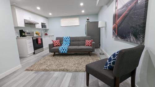a living room with a couch and a chair at SERENE & MODERN 1BED SUITE + CLOSE TO AIRPORT in Regina
