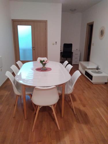 a white dining room table with white chairs and a table at Marys Home Apartment Međugorje in Međugorje