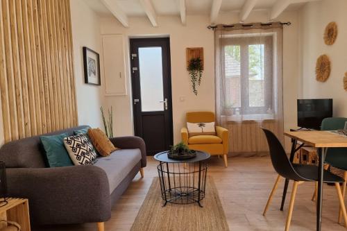 ein Wohnzimmer mit einem Sofa und einem Tisch in der Unterkunft Rive Sud - Charmante Maisonette 2 P - Stadtzentrum in Honfleur