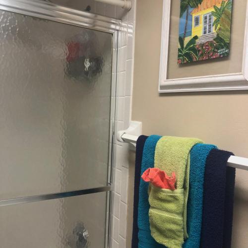 a bathroom with a shower with a towel and a refrigerator at Beach bungalow at Ocean Village in Fort Pierce