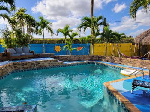 a swimming pool with blue water and palm trees at The Driftwood Oasis in West Palm Beach