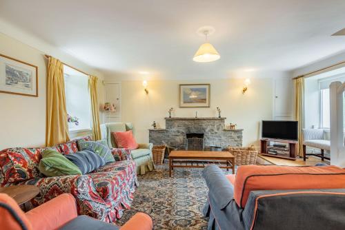 a living room with couches and a fireplace at Cwm Farm in Trearddur