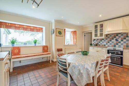 a kitchen with a table and chairs in a kitchen at Cwm Farm in Trearddur