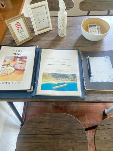 einen Tisch mit Büchern und anderen Artikeln darauf in der Unterkunft Holiday Cottage BANSHIRO in Setouchi