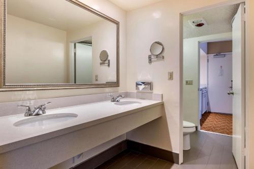 La salle de bains est pourvue de 2 lavabos, d'un miroir et de toilettes. dans l'établissement Best Western Plus Thousand Oaks Inn, à Thousand Oaks