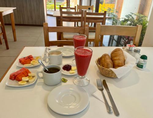 a table with breakfast foods and drinks on it at Hotel El Geranio in Otavalo