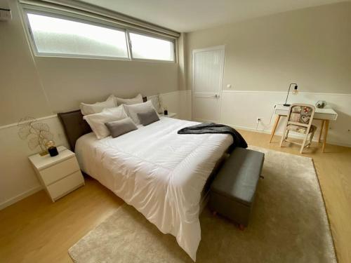 une chambre avec un grand lit blanc avec une fenêtre dans l'établissement Villa Família, à Ponta Delgada