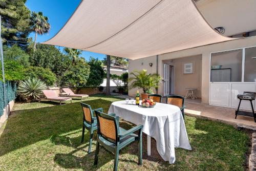 a table and chairs under a tent in a yard at Villa Tamarells - Alcúdia in Alcudia