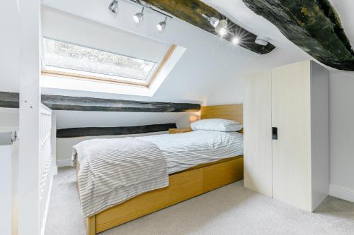 a bedroom with a bed and a window at Weavers Cottage in Hebden Bridge