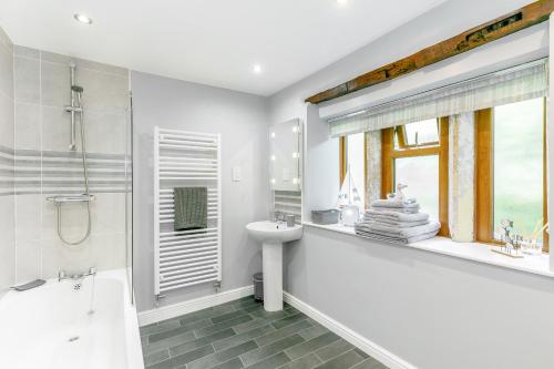uma casa de banho branca com uma banheira, um lavatório e um WC. em Weavers Cottage em Hebden Bridge