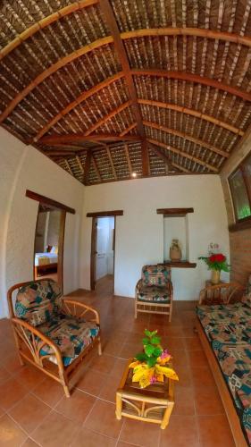 a living room with couches and a wooden ceiling at Hosteria Cumilinche in Same
