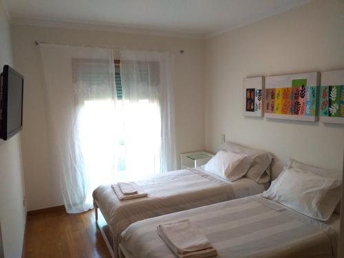 Giường trong phòng chung tại H2OPorto Beachfront Apartment