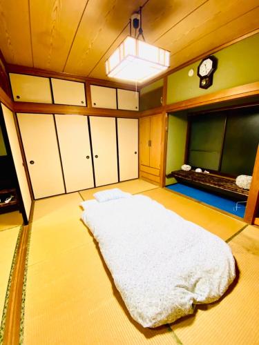 a bedroom with a large white bed in a room at Holiday Cottage BANSHIRO in Setouchi