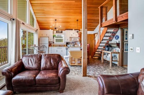 a leather couch in a living room with a kitchen at Salty Kisses in Ocean Shores