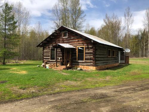 a small log cabin on a grassy field at Mini-Mooh cabin in Clearwater