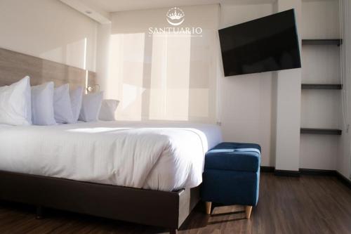 a hotel room with a bed and a flat screen tv at HOTEL SANTUARIO in Tunja