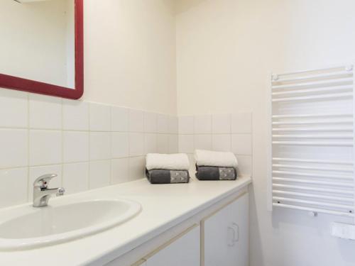 a white bathroom with a sink and a mirror at Gîte Saint-Malo-de-Guersac, 2 pièces, 2 personnes - FR-1-306-862 in Saint-Malo-de-Guersac