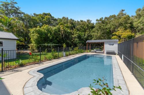 a swimming pool in a yard with a fence at Bayview Beach House - Pet Friendly Holiday Home with a Pool - Holiday Yamba in Yamba