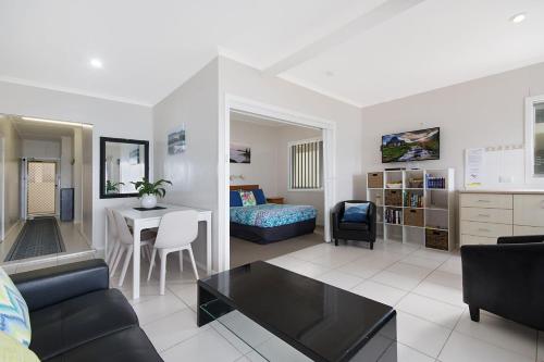 a living room with a couch and a table at Boorolong 3 - Linen not provided in Yamba