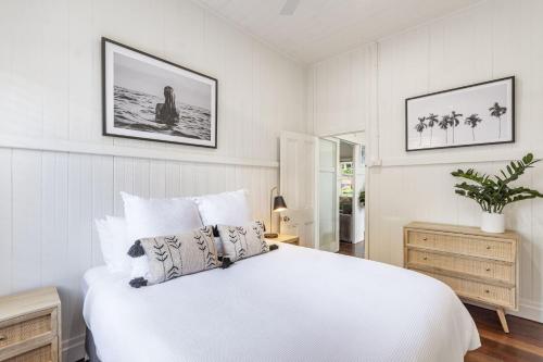 a white bedroom with a large white bed in it at High Three - Downtown Beach House in Yamba