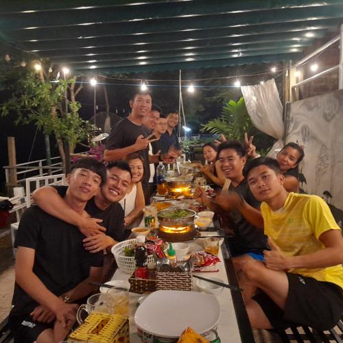 a group of people sitting around a table at a party at Carambola Bungalow in Phong Nha