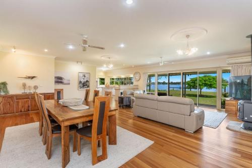 a living room with a dining table and a couch at Island Getaway - Waterfront near Yamba in Woombah