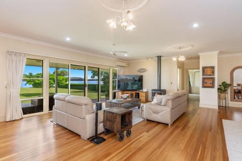 a living room with two chairs and a table at Island Getaway - Waterfront near Yamba in Woombah