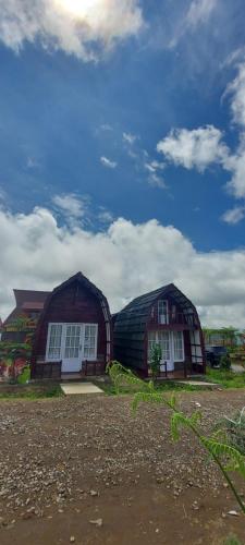 deux grands bâtiments en dôme sur un champ avec ciel dans l'établissement Villa Lorong Sempit Puncak 2000 Siosar, à Pertibi