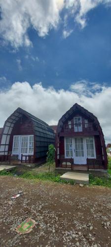 dois grandes edifícios de madeira sentados um ao lado do outro em Villa Lorong Sempit Puncak 2000 Siosar em Pertibi