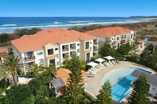 an aerial view of a resort with a swimming pool and the ocean at Villa 63 - Resort Style Living - Holiday Yamba in Yamba