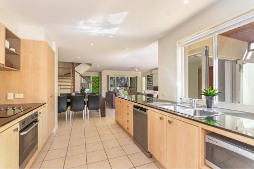 an open kitchen with a sink and a counter at Villa 63 - Resort Style Living - Holiday Yamba in Yamba