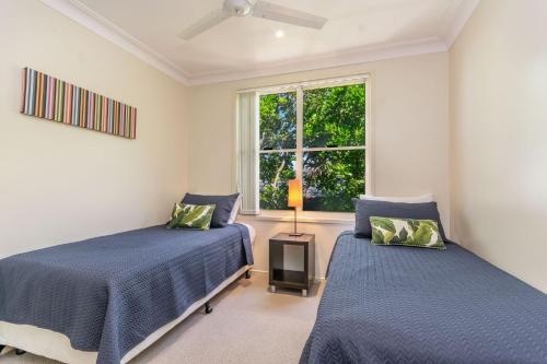 a bedroom with two beds and a window at Villa 63 - Resort Style Living - Holiday Yamba in Yamba