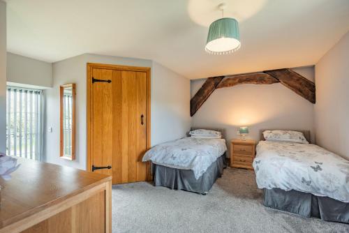 DyffrynにあるGwrtheyrnのベッドルーム1室(ベッド2台付)、木製のドアが備わります。