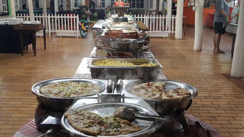 una línea de buffet con muchos tipos diferentes de comida en Campo Belo Resort en Álvares Machado