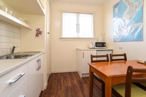 een keuken met een tafel en een eetkamer bij Sunny Mornington 2 Bedroom Guest Suite in Dunedin