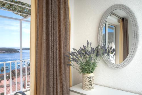 een spiegel en een vaas met een plant op een raam bij Bucket List - Hvar in Hvar