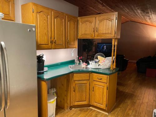 a kitchen with wooden cabinets and a refrigerator at Cedar Vista Motel in Tobermory