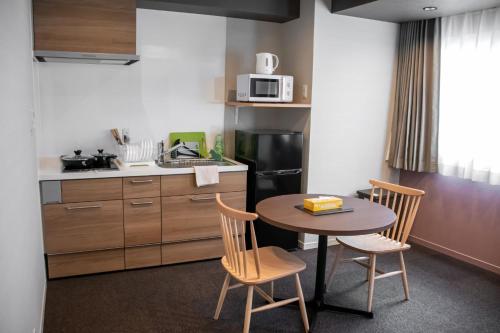 a kitchen with a table and two chairs and a sink at Hotel S-Presso West - Vacation STAY 9085 in Osaka