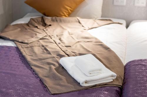 a pile of towels sitting on a bed at Hotel S-Presso West - Vacation STAY 9085 in Osaka