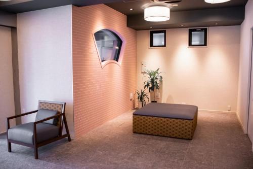 a waiting room with a bed and a chair at Hotel S-Presso West - Vacation STAY 9085 in Osaka